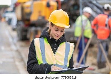 female construction worker managing team at building site