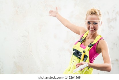 Female Construction Worker With Putty Knife Over Obsolete Background 