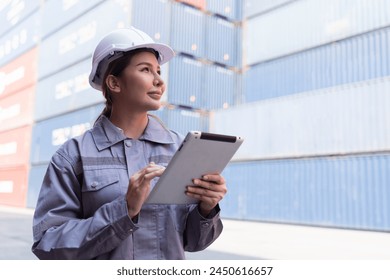 Female container yard worker loading containers box at commercial dock site. Female worker control loading container box from cargo freight ship for import export