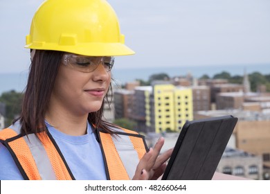 Female Contractor At A Work Site Using An Ipad/tablet