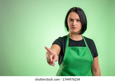 Female Cook With Green Apron And Black T-shirt, Showing No With Her Finger Isolated On Green Background