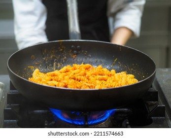 Female Cook Tossing Egg Pasta In The Pan