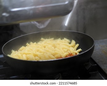 Female Cook Tossing Egg Pasta In The Pan