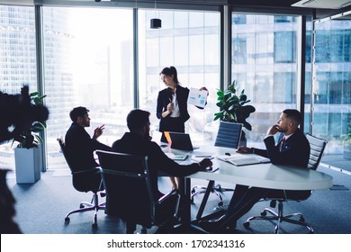 Female corporate director in formal clothing training group of successful professionals during brainstorming conference for search strategy solutions, financial experts discussing business contract - Shutterstock ID 1702341316
