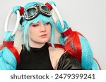 A female cosplayer dressed as an anime character with blue hair and a megaphone