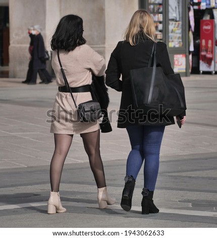  Female couple walking in Duomo square, Milan, Italy