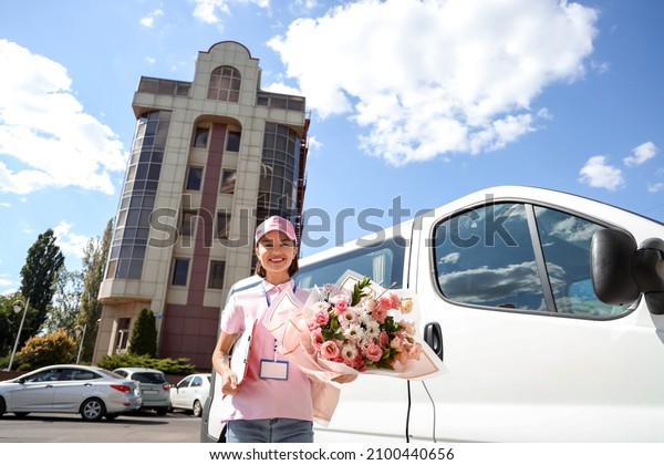 Female courier\
with bouquet of flowers\
outdoors