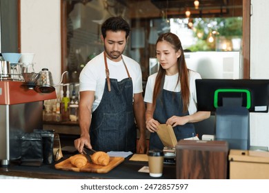 Female in a cozy cafe setting, focuses intently on tablet beside a croissant and hot beverage. Cafe's tranquility surrounds woman engrossed in digital tablet, breakfast pastry and coffee cup nearby - Powered by Shutterstock