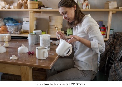 A Female Craftsman In An Art Workshop Is Making Vintage Wooden Toys.