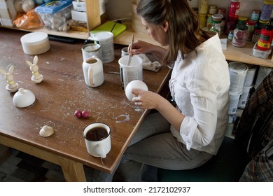 A Female Craftsman In An Art Workshop Is Making Vintage Wooden Toys.