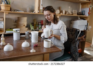 A Female Craftsman In An Art Workshop Is Making Vintage Wooden Toys.