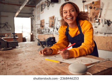 Female Craftsman In Carpentry Workshop For Bamboo Bicycles Using Digital Tablet And Smart Speaker - Powered by Shutterstock