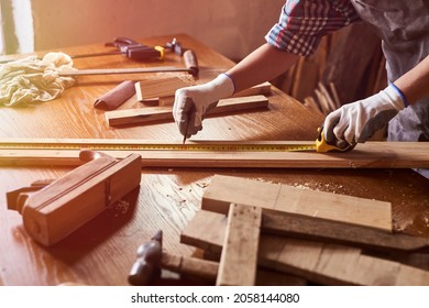 Female craftsmen use tape measure to assemble wooden pieces. Professional carpenter at work measuring wooden planks.  - Powered by Shutterstock