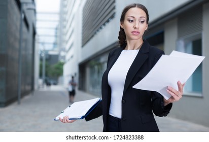 Female Creative Director Is Examining Documents Before Signing Outdoors.