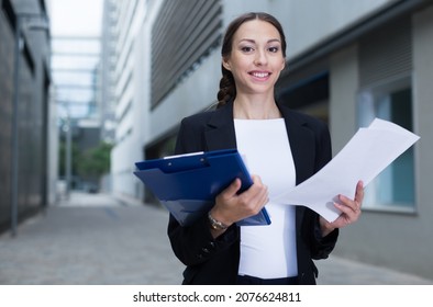 Female Creative Director Is Examining Documents Before Signing Outdoors.