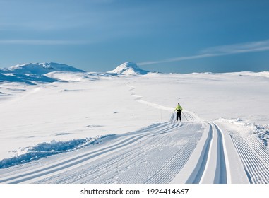 Female cross country skier enjoying well groomed tracks in the norwegian mountains at easter