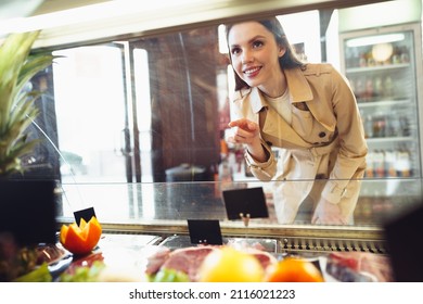 Female Customer Against Raw Meat Stall Section In Food Store