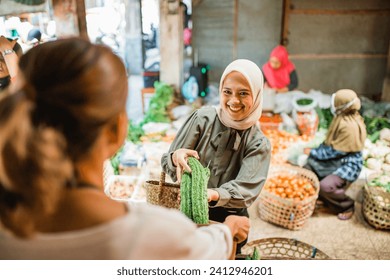 female customer buying fresh vegetables from traditional farmer market - Powered by Shutterstock