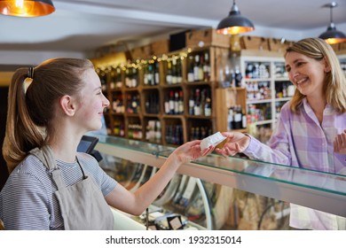 Female Customer Delicatessen Food Store Buying Local Cheese From Teenage Sales Assistant