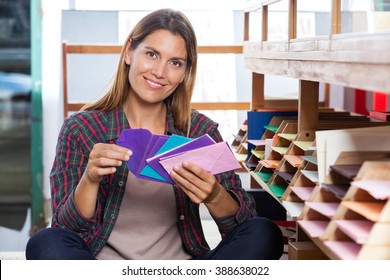 Female Customer Holding Envelops By Shelves