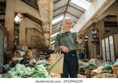 female customer holding phone and standing at farmer market - Powered by Shutterstock