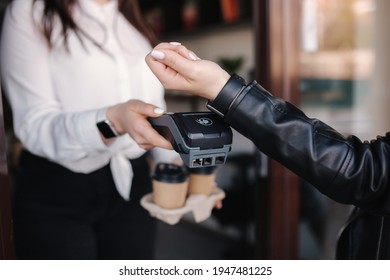 Female customer making wireless or contactless payment using smartwatch. Cashier accepting payment over nfc technology. Two people in face mask during quarantine. Covid19 - Powered by Shutterstock