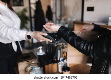 Female customer making wireless or contactless payment using smartwatch. Closeup of hands during payment. Store worker accepting payment over nfc technology - Powered by Shutterstock