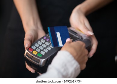 Female customer pay hold credit card use contactless nfc technology concept, woman consumer make transaction payment on wireless terminal rfid pos reader machine in restaurant store, close up view