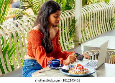 Female Customer Paying For Coffee And Pancakes With Credit Card Sitting With Laptop Online Shopping Black Friday Sale