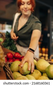 Female Customer Picking Some Organic Fruits In The Fresh Produce Section Of A Grocery Store. Happy Young Woman Grocery Shopping In A Trendy Supermarket.