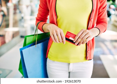 Female Customer With Plastic Card And Shopping Bags In The Mall