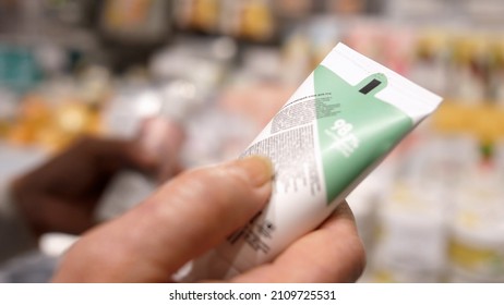 Female Customer Reading Label on Cosmetic Bottle In Supermarket. 4K. Close up - Powered by Shutterstock