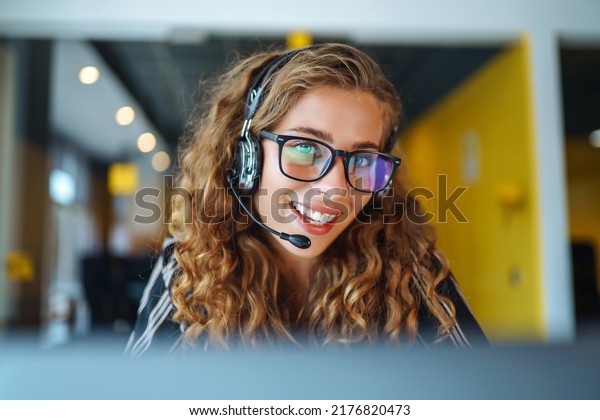 Female\
customer service representative in a headset is consulting clients\
online. Call center and business people\
concept