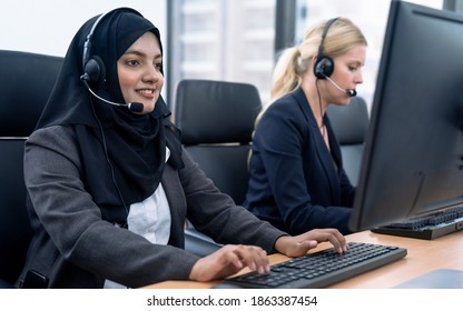 Female customer services agent with headset working in a call center.