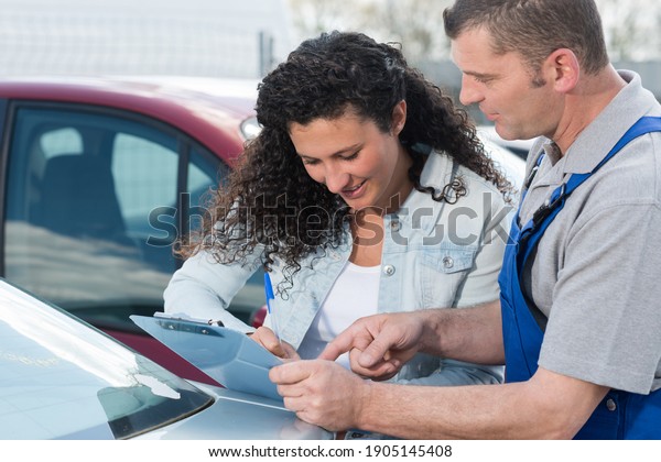 female customer\
signing mechanics\
paperwork