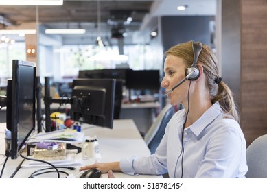 Female Customer Support Phone Operator With Headset  At Workplace