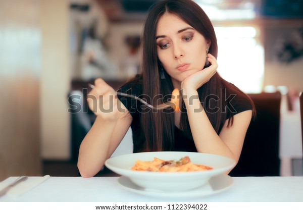 Female Customer\
Unhappy with the Dish Course in Restaurant. Depressed lonely woman\
suffering from appetite\
loss