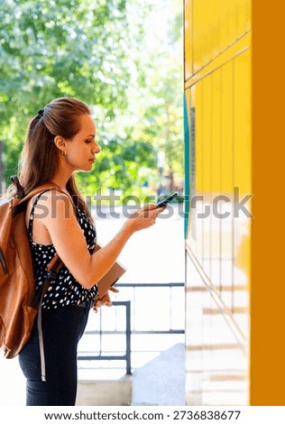 Female customer using mobile app to collect parcel from locker.