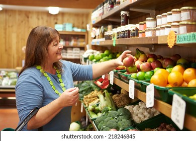 Female Customer At Vegetable Counter Of Farm Shop