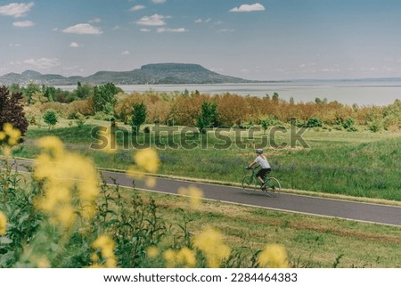 Female cyclist cycling by the lake Balaton