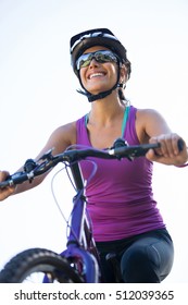 Female cyclist cycling in countryside on sunny day - Shutterstock ID 512039365