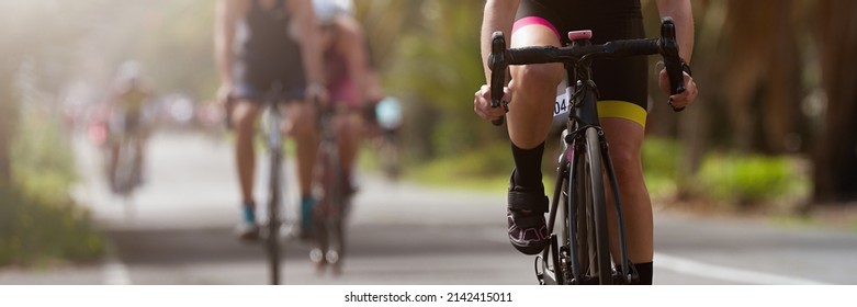 Female cyclist riding racing bicycle, woman cycling on countryside summer road. Training for triathlon or cycling competition - Shutterstock ID 2142415011