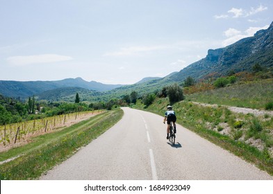 Female Cyclist Riding Through Mountain Road Forest