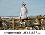 Female cyclist taking a break on a scenic overlook, enjoying the panoramic view. Wearing stylish cycling apparel and helmet. Perfect for active lifestyle, travel, and sports themes.