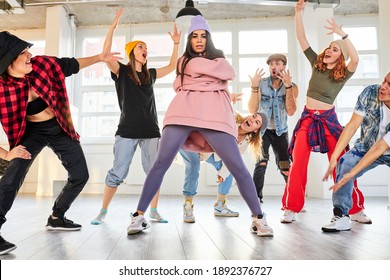 Female Dance Teacher Recording A New Dance Video In Studio With Pupils, Dancers Having A Rehearsal Together