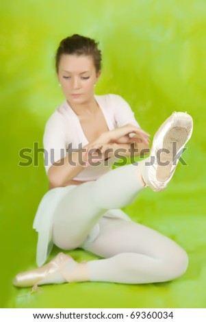 Female dancer in ballet shoes exercising in pointe over green
