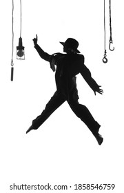 A female dancer dances on stage. Dressed in men's 
clothing and wearing a man's hat, she is seen leaping 
in mid air as a silhouette.