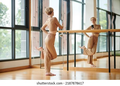 Female Dancer Taking Selfie In Front Of Big Mirror In Dance Studio