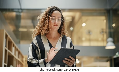 Female Data Analyst Smiling While Checking New Data for the Day. Portrait of hispanic Businesswoman Walking Towards her Business Office in a Spacious Corporate Building. Low Angle