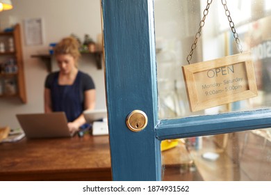 Female Delicatessen Owner At Checkout Seen Through Shop Door - Powered by Shutterstock